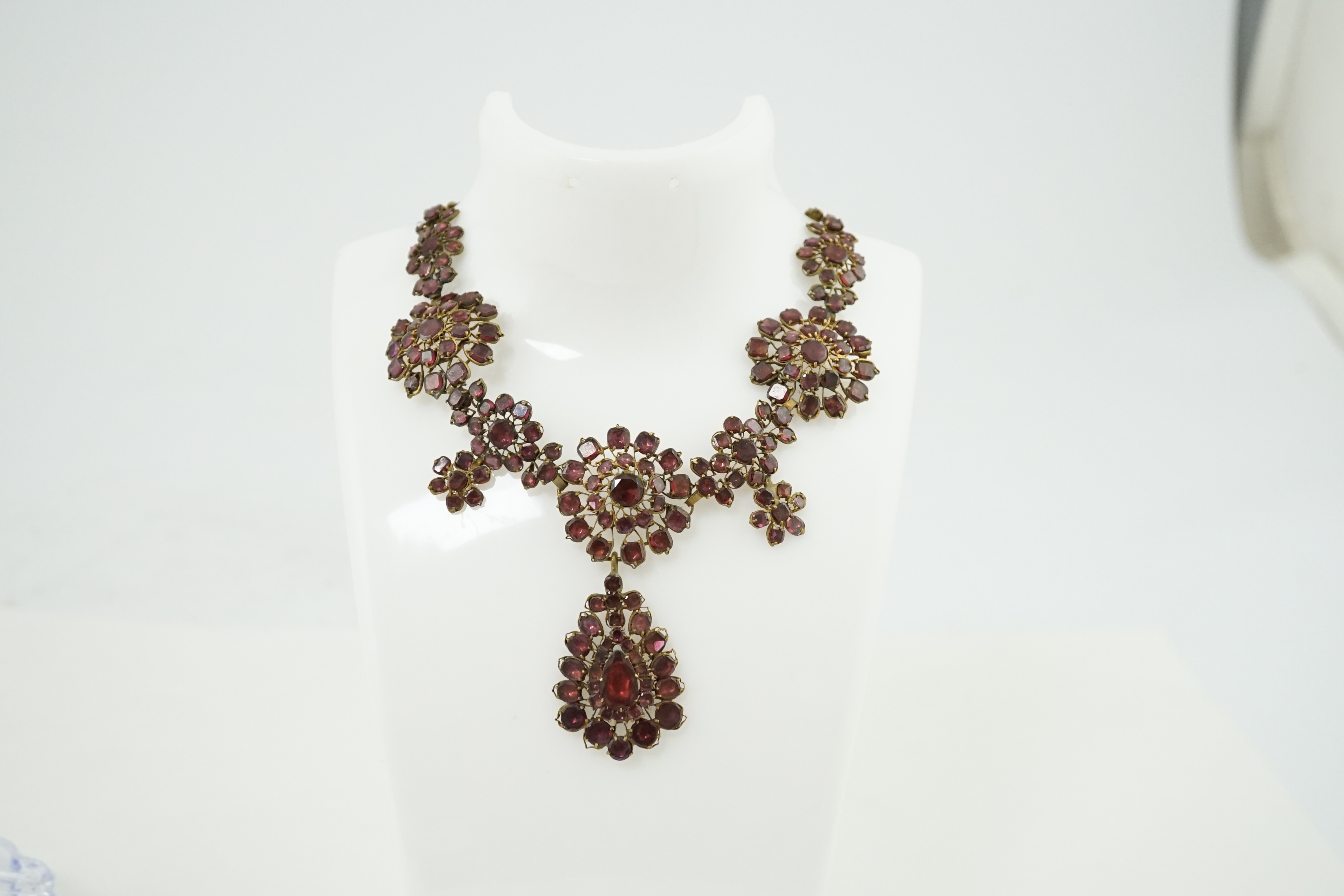 A good 18th century gilt metal and foil backed garnet cluster drop necklace, in original box